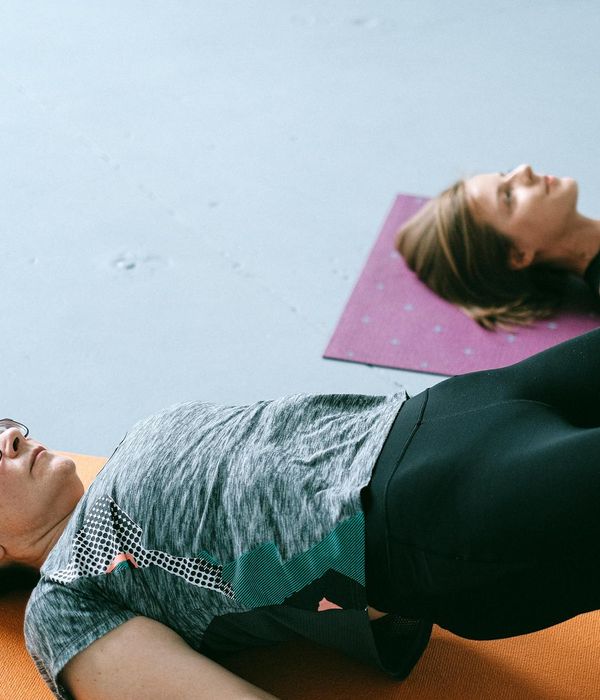 Group of women practicing yoga together in a sunlit studio.